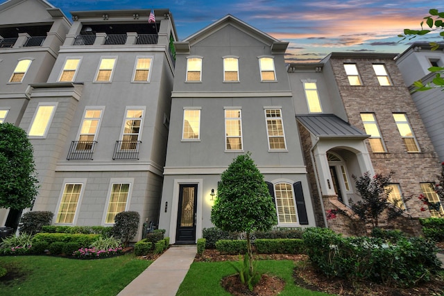 861 Dunleigh Meadows Ln, Houston, TX 77055 - townhome / multi-family property featuring stucco siding, a standing seam roof, a yard, and a metal roof