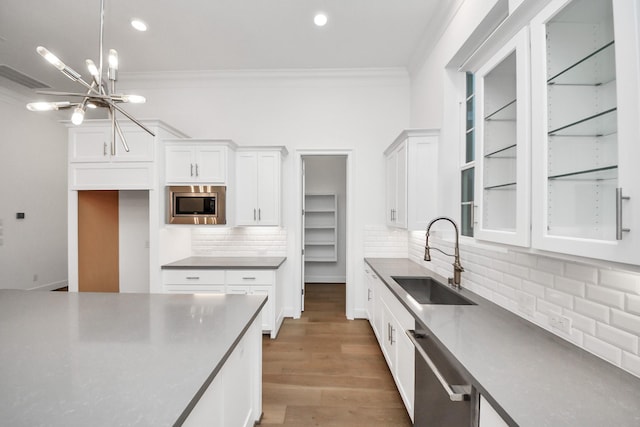 861 Dunleigh Meadows Ln, Houston, TX 77055 - kitchen with stainless steel appliances, ornamental molding, white cabinetry, tasteful backsplash, and a chandelier