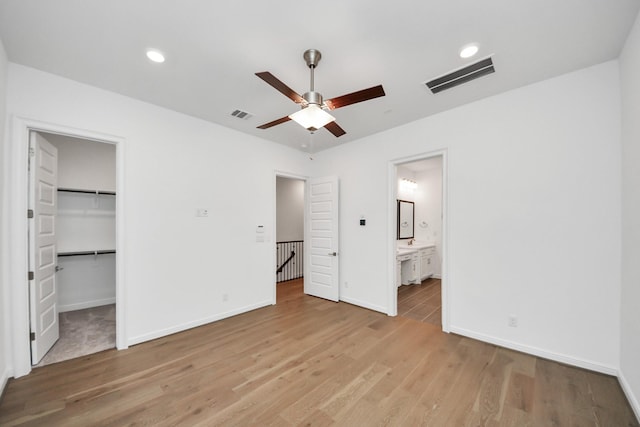 861 Dunleigh Meadows Ln, Houston, TX 77055 - unfurnished bedroom with light wood-style flooring, ensuite bath, a walk in closet, ceiling fan, and recessed lighting