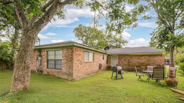 516 W Mimosa St, Angleton, TX 77515 - rear view of house with brick siding and a lawn