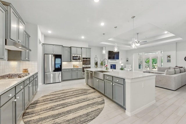 250 Peninsula Point Dr, Montgomery, TX 77356 - kitchen featuring appliances with stainless steel finishes, gray cabinets, ceiling fan, under cabinet range hood, and open floor plan