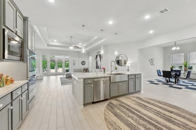 250 Peninsula Point Dr, Montgomery, TX 77356 - kitchen featuring appliances with stainless steel finishes, open floor plan, gray cabinets, light wood-style flooring, and recessed lighting