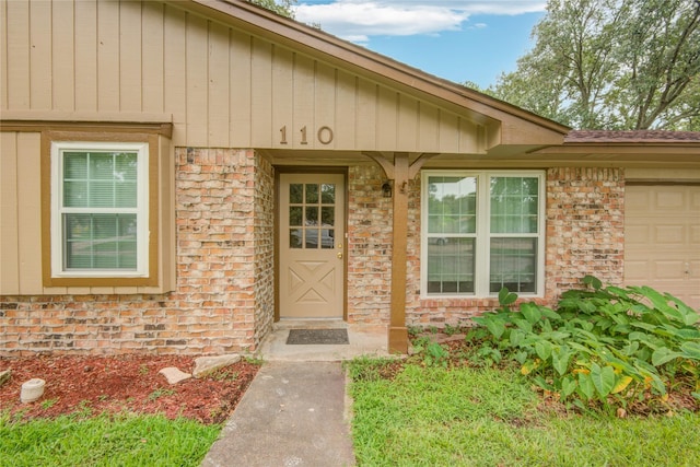 110 Spruce St, Lake Jackson, TX 77566 - view of exterior entry with brick siding and an attached garage