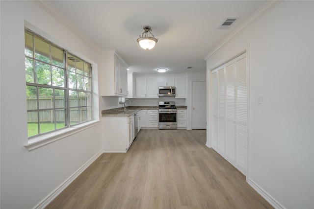 110 Spruce St, Lake Jackson, TX 77566 - kitchen with appliances with stainless steel finishes, light wood-type flooring, white cabinetry, ornamental molding, and stone counters