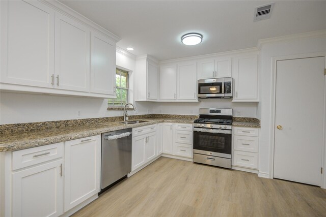 110 Spruce St, Lake Jackson, TX 77566 - kitchen with appliances with stainless steel finishes, white cabinetry, light wood-style flooring, light stone countertops, and recessed lighting