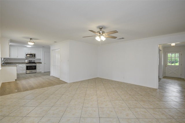 110 Spruce St, Lake Jackson, TX 77566 - unfurnished living room with a ceiling fan, crown molding, and light tile patterned floors