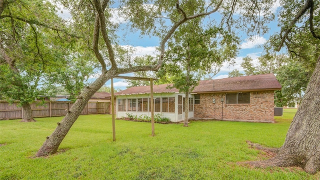 110 Spruce St, Lake Jackson, TX 77566 - rear view of property featuring a sunroom and brick siding