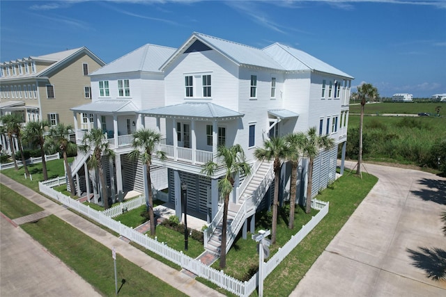 742 Positano Rd, Galveston, TX 77550 - view of front of house featuring driveway, stairs, a porch, and a metal roof