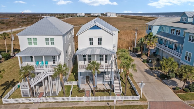 742 Positano Rd, Galveston, TX 77550 - rear view of property featuring covered porch, a metal roof, and stairway