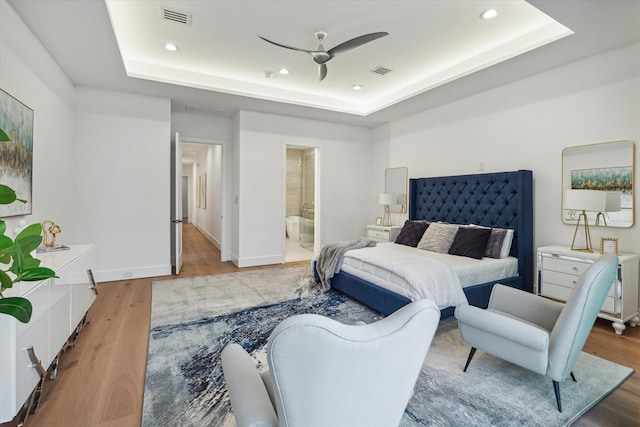 507 W Bell, Houston, TX 77019 - bedroom featuring a raised ceiling, wood finished floors, recessed lighting, and ensuite bath