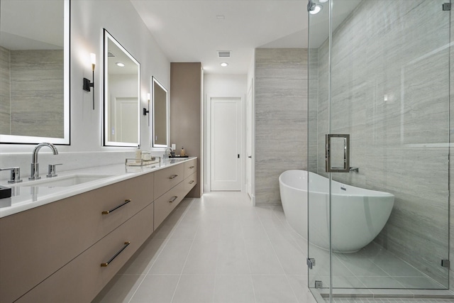 507 W Bell, Houston, TX 77019 - bathroom with double vanity, a freestanding tub, tile walls, a stall shower, and tile patterned floors