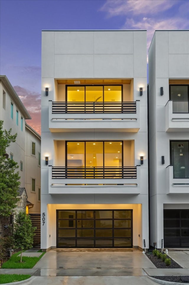 507 W Bell, Houston, TX 77019 - view of front of home with a garage, a balcony, driveway, and stucco siding