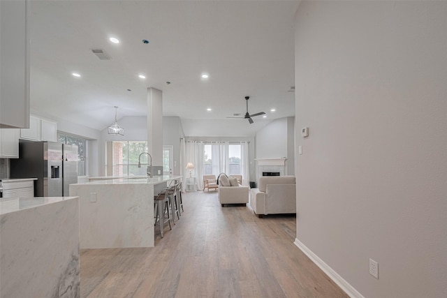 7602 Las Flores Dr, Houston, TX 77083 - kitchen with stainless steel fridge, white cabinetry, recessed lighting, a ceiling fan, and light wood finished floors