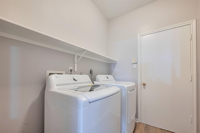 7602 Las Flores Dr, Houston, TX 77083 - laundry room featuring separate washer and dryer and light wood-style flooring
