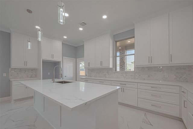 3525 Federal Rd, Pasadena, TX 77504 - kitchen with light marble finish floors, recessed lighting, decorative backsplash, white cabinets, and a center island with sink