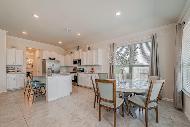 2226 Blakely Grove Ln, Richmond, TX 77469 - kitchen with appliances with stainless steel finishes, ornamental molding, tasteful backsplash, a center island with sink, and white cabinetry