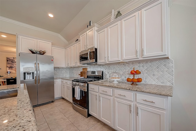 2226 Blakely Grove Ln, Richmond, TX 77469 - kitchen featuring stainless steel appliances, white cabinets, vaulted ceiling, light tile patterned floors, and tasteful backsplash