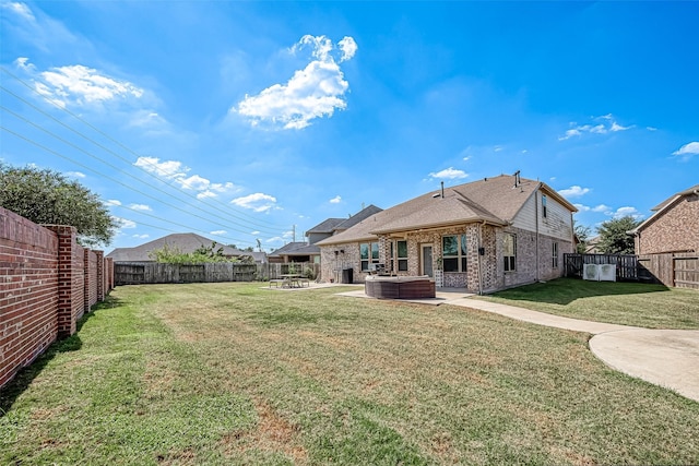 2226 Blakely Grove Ln, Richmond, TX 77469 - back of property featuring a fenced backyard, a hot tub, brick siding, a patio, and a shingled roof