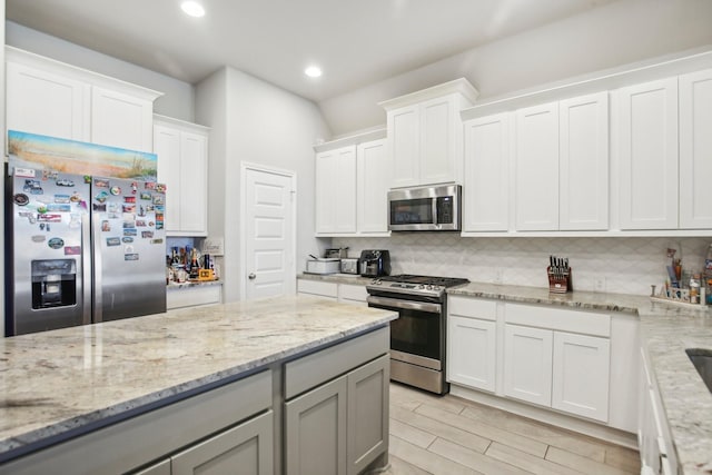 19822 Blue Roan Dr, Tomball, TX 77377 - kitchen with stainless steel appliances, tasteful backsplash, recessed lighting, white cabinets, and light stone countertops
