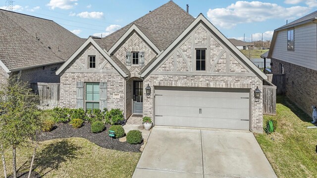 19822 Blue Roan Dr, Tomball, TX 77377 - view of front of home featuring driveway, roof with shingles, brick siding, an attached garage, and stone siding