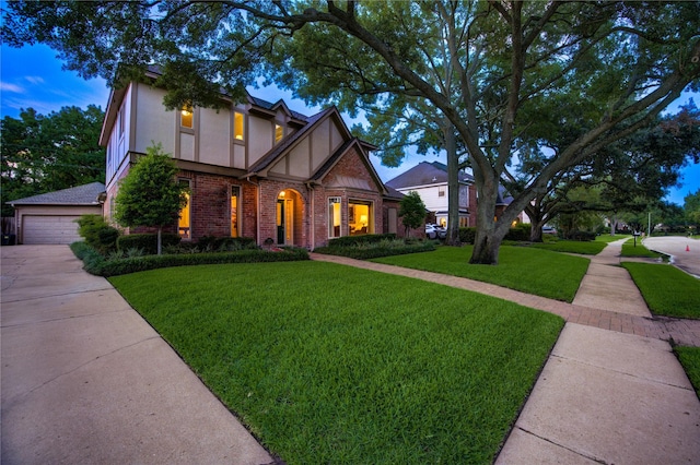 11410 Del Monte Dr, Houston, TX 77077 - tudor-style house with stucco siding, brick siding, a front yard, and a detached garage