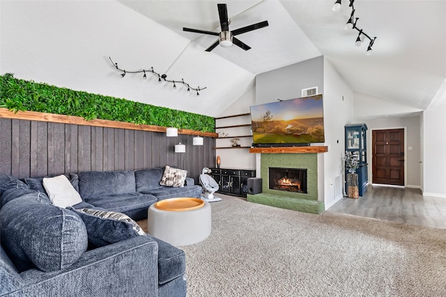 2806 Spring Dusk Ln, Spring, TX 77373 - carpeted living area with track lighting, vaulted ceiling, a ceiling fan, and a warm lit fireplace