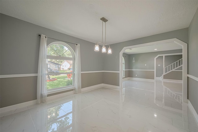 12206 Green Glade Dr, Houston, TX 77099 - unfurnished room with marble tiled flooring, arched walkways, and a textured ceiling