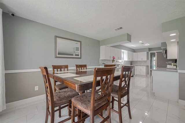 12206 Green Glade Dr, Houston, TX 77099 - dining space with light marble finish flooring and a textured ceiling