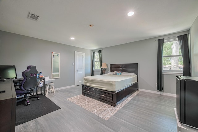 12206 Green Glade Dr, Houston, TX 77099 - bedroom featuring multiple windows, light wood finished floors, recessed lighting, and an office area