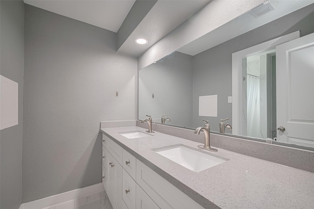 12206 Green Glade Dr, Houston, TX 77099 - full bathroom with double vanity, marble look tiles, and recessed lighting