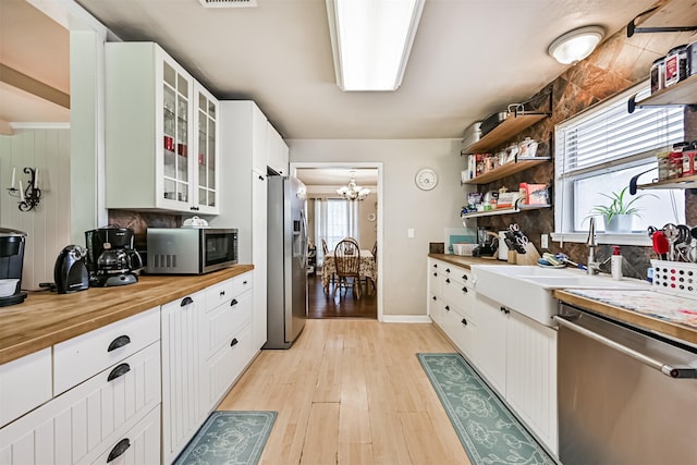 114 Wyndwood Dr, Seabrook, TX 77586 - kitchen with appliances with stainless steel finishes, wood counters, open shelves, light wood-style floors, and decorative backsplash