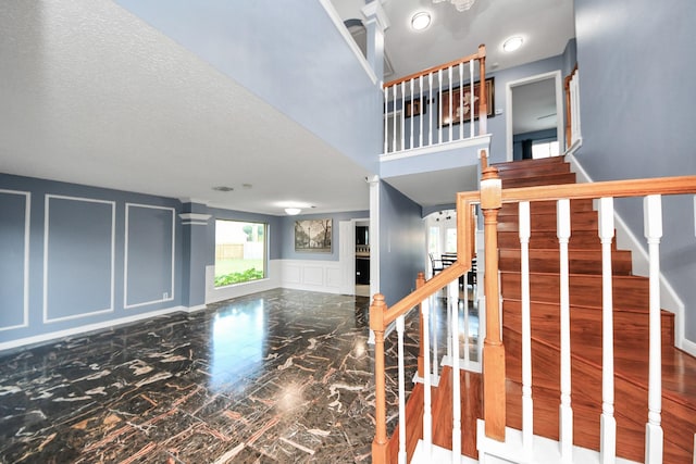 14907 Leila Oaks Cir, Houston, TX 77082 - stairway featuring a decorative wall, marble tiled flooring, and wainscoting