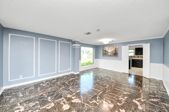 14907 Leila Oaks Cir, Houston, TX 77082 - unfurnished room featuring a decorative wall, a textured ceiling, marble finish flooring, wainscoting, and crown molding