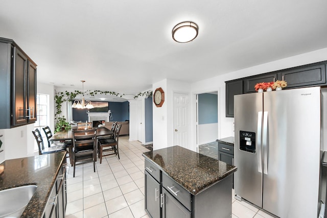 14907 Leila Oaks Cir, Houston, TX 77082 - kitchen featuring stainless steel fridge with ice dispenser, light tile patterned flooring, a kitchen island, dark stone countertops, and open floor plan