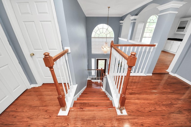 14907 Leila Oaks Cir, Houston, TX 77082 - stairway featuring crown molding, wood finished floors, arched walkways, and ornate columns