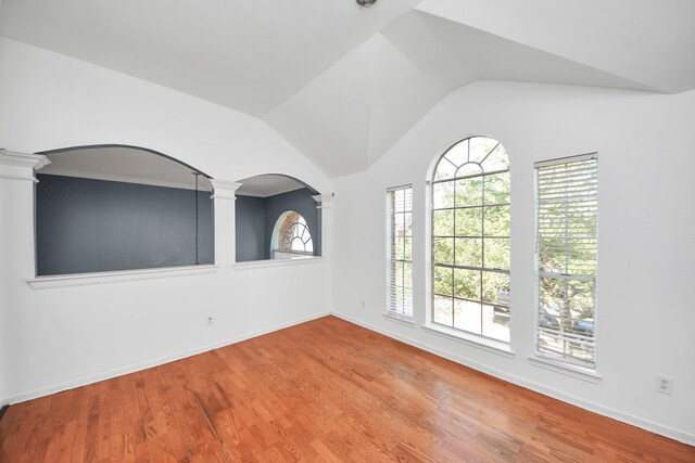 14907 Leila Oaks Cir, Houston, TX 77082 - unfurnished room featuring decorative columns, arched walkways, healthy amount of natural light, wood finished floors, and vaulted ceiling