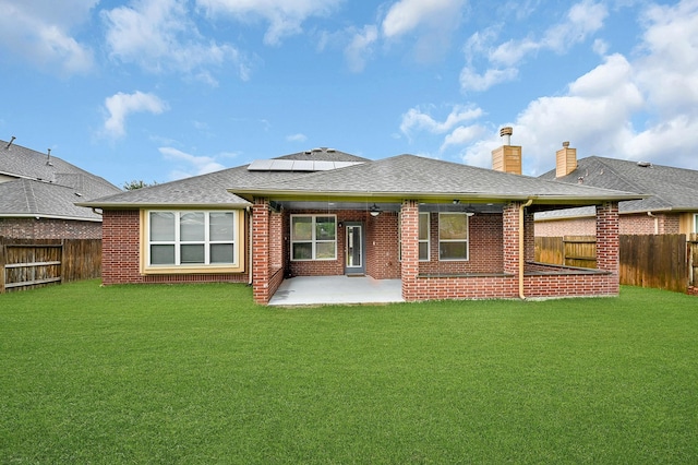 706 Overdell Dr, Sugar Land, TX 77479 - back of house with a fenced backyard, brick siding, and roof mounted solar panels