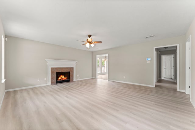 519 Tallow Dr, Conroe, TX 77385 - unfurnished living room featuring ceiling fan, light wood finished floors, and a fireplace