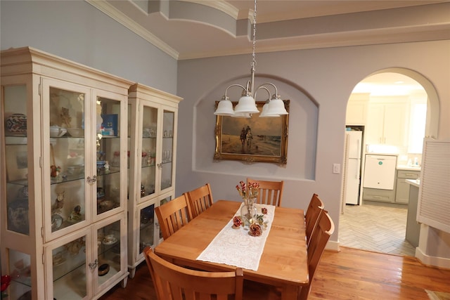 212 Greenwood St, Houston, TX 77011 - dining room featuring ornamental molding, arched walkways, and light wood-type flooring