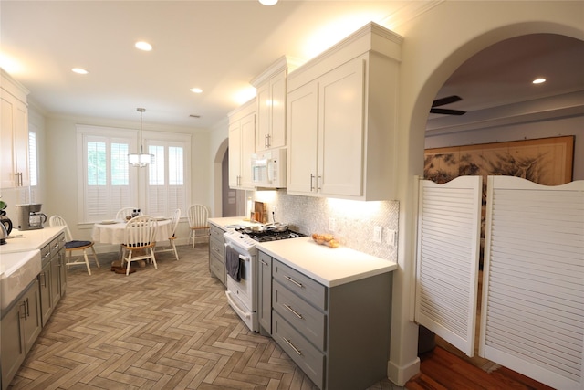 212 Greenwood St, Houston, TX 77011 - kitchen with white appliances, gray cabinets, arched walkways, light countertops, and recessed lighting