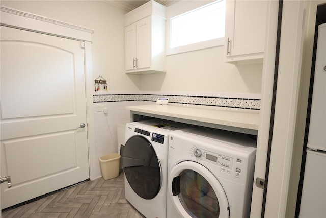 212 Greenwood St, Houston, TX 77011 - laundry room featuring cabinet space, washing machine and clothes dryer, tile walls, a wainscoted wall, and ornamental molding