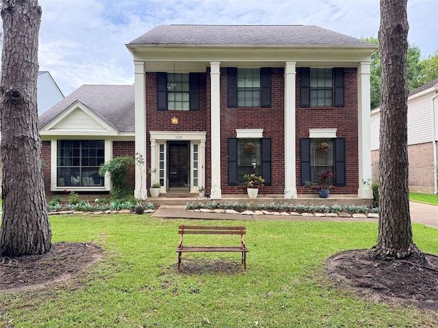 128 Hidden Lake Dr, League City, TX 77573 - greek revival house featuring brick siding, a front lawn, and a shingled roof