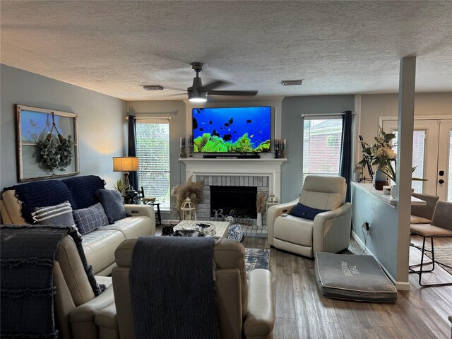 128 Hidden Lake Dr, League City, TX 77573 - living area with ceiling fan, wood finished floors, plenty of natural light, a fireplace, and a textured ceiling
