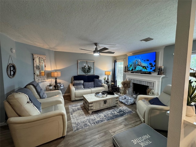 128 Hidden Lake Dr, League City, TX 77573 - living room with a ceiling fan, a textured ceiling, wood finished floors, and a brick fireplace