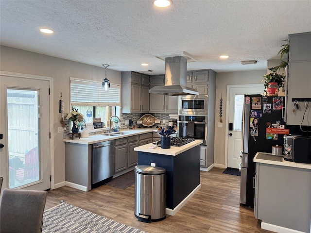 128 Hidden Lake Dr, League City, TX 77573 - kitchen featuring appliances with stainless steel finishes, island exhaust hood, gray cabinets, light countertops, and a kitchen island
