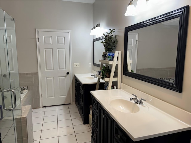 128 Hidden Lake Dr, League City, TX 77573 - full bathroom featuring two vanities, a shower stall, a bath, and tile patterned flooring