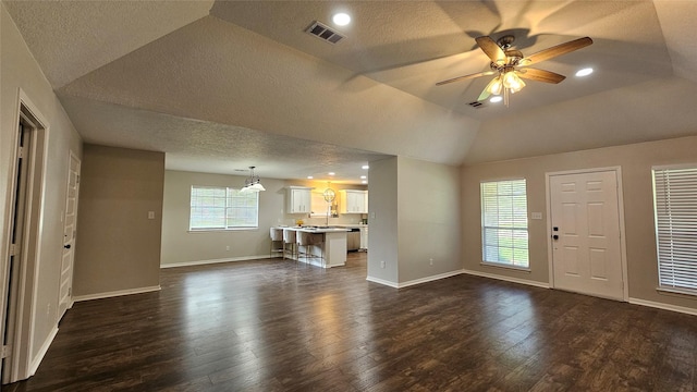 2402 Heather St, Highlands, TX 77562 - unfurnished living room with a textured ceiling, dark wood-style flooring, a ceiling fan, and vaulted ceiling