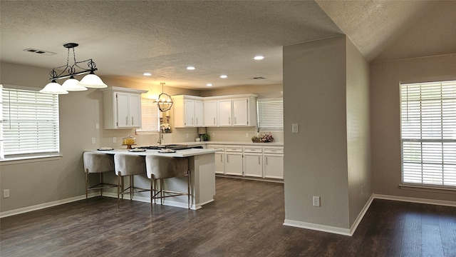 2402 Heather St, Highlands, TX 77562 - kitchen with a peninsula, white cabinetry, a textured ceiling, light countertops, and recessed lighting