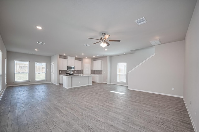 24711 Sonora Crescent Cir, Huffman, TX 77336 - unfurnished living room with wood finished floors, healthy amount of natural light, a ceiling fan, and recessed lighting