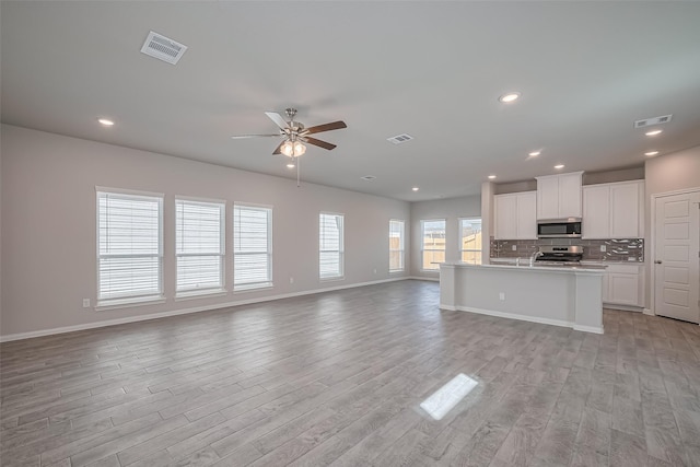 24711 Sonora Crescent Cir, Huffman, TX 77336 - unfurnished living room featuring a ceiling fan, light wood finished floors, and recessed lighting